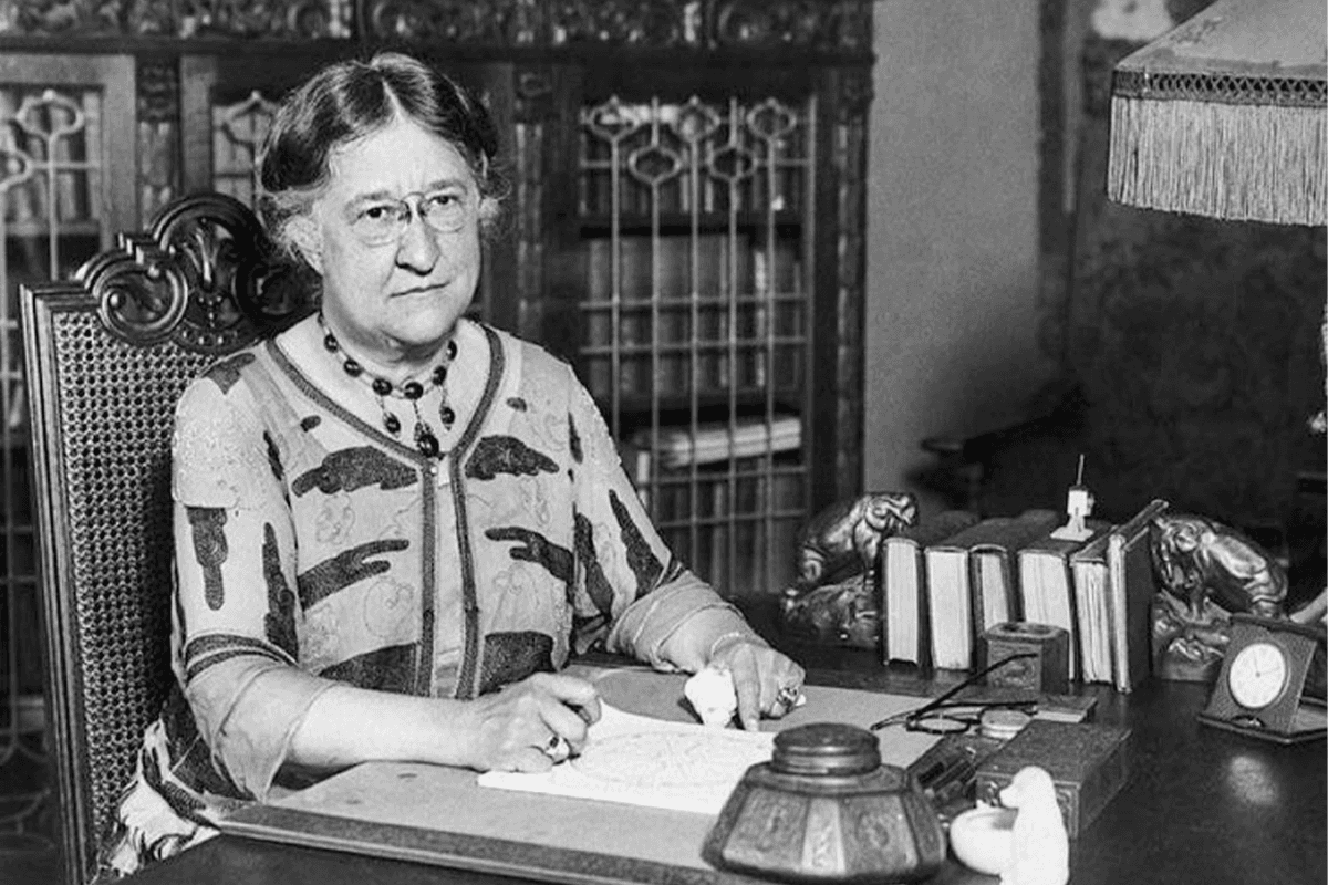 Press photograph of the astrologer Evangeline Adams at her desk, casting a chart